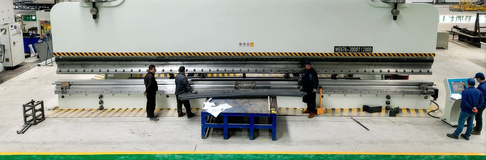 Heavy-duty multi-axis CNC press brake forming a long steel profile across its full bed length