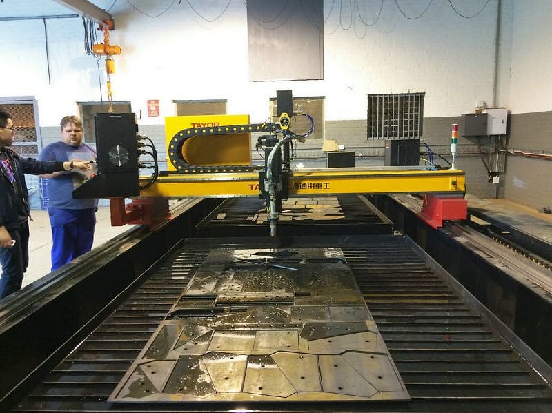Nested parts profile-cut from a heavy steel plate on the cutting bed